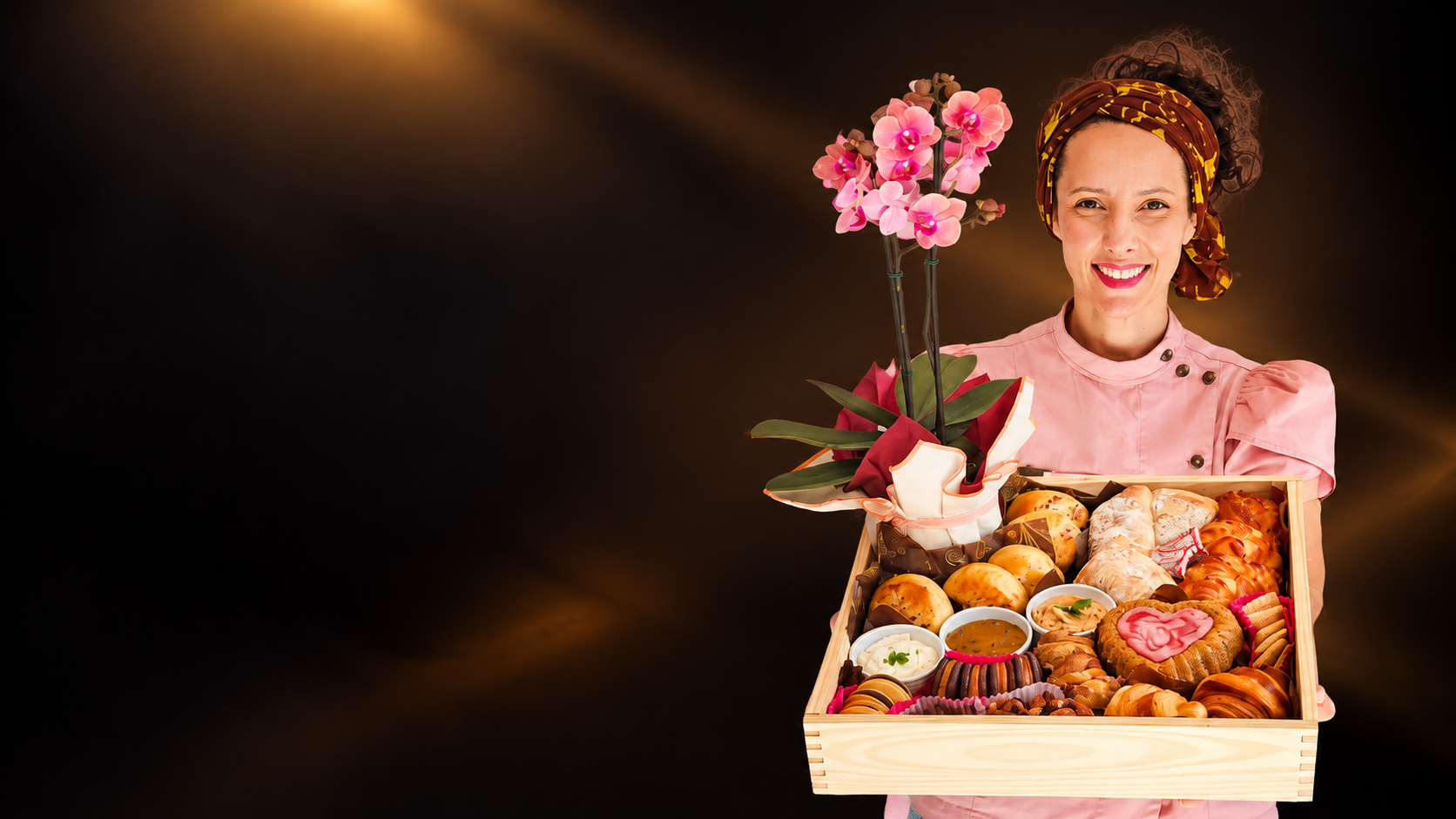 Gio com uma cesta artesanal repleta de pães, acompanhamentos e uma orquídea